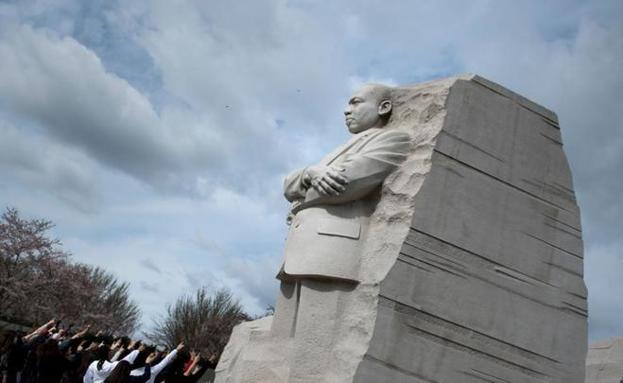 Un grupo de personas señala la estatua en honor a Martin Luther King en Washington./Afp