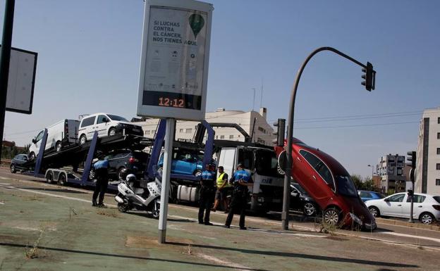 Un coche se cae de un camión portavehículos en un semáforo de la avenida de Madrid, en Valladolid