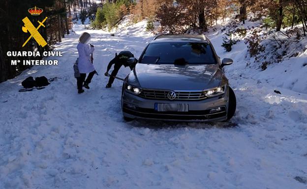 Dos horas retirando hielo y nieve para auxiliar a una familia atrapada con su coche en Quintanar