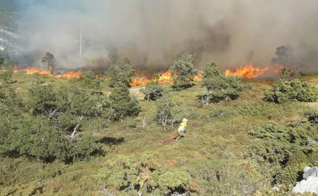 Medios aéreos y terrestres luchan por extinguir el fuego en Porquera del Butrón